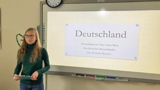 Na-zdjeciu-uczennica-klasy-pierwszej-przy-tablicy-prezentuje-informacje-o-Niemczech
