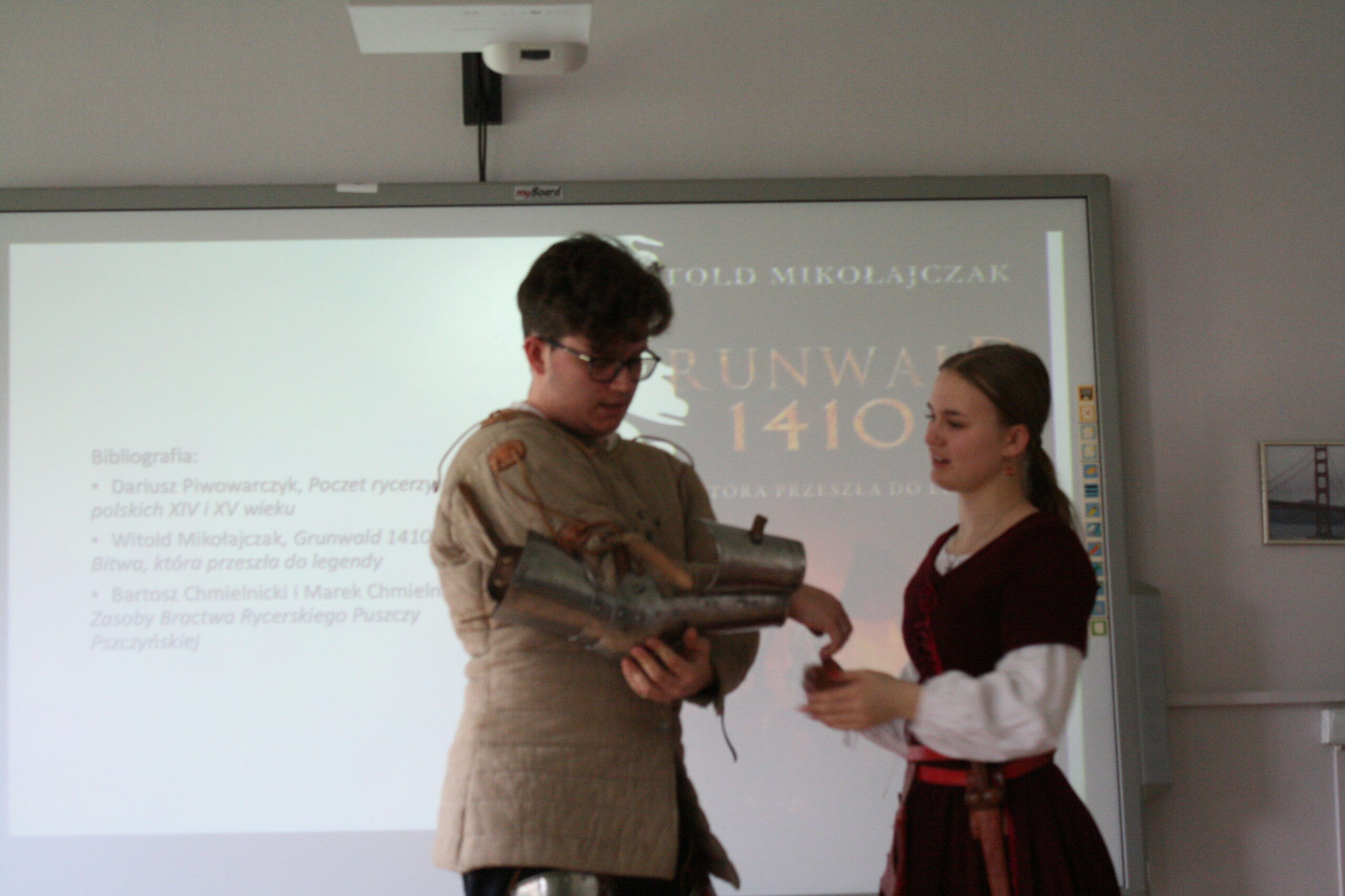 Uczeń i uczennica prezentują zbroję